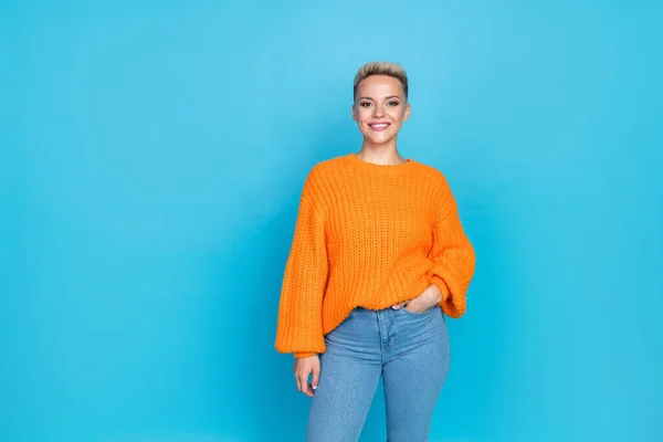 美しい若い女性の写真ポージングショッピングモデルの手のポケット陽気な着用トレンディーなオレンジの服は青の色の背景に隔離 — ストック写真