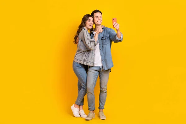 魅力的な甘いカップルの完全な長さの写真は ジーンズを着用ビデオVlog現代的なデバイス孤立黄色の背景を記録 — ストック写真
