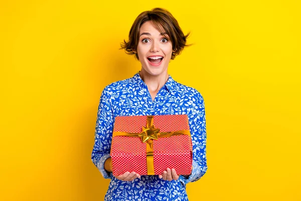 Photo of excited funky lady wear print shirt getting red gift package isolated yellow color background.
