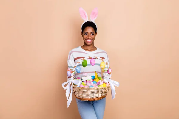 素敵な若い短いヘアドウサギの女性の写真は ベージュの色の背景に隔離された白いセーターを着てお菓子を保持 — ストック写真