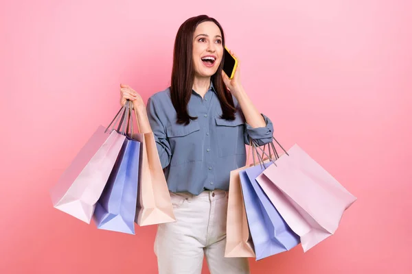 Photo of excited positive lovely lady wear trendy clothes speaking telephone courier delivery service isolated on pink color background.
