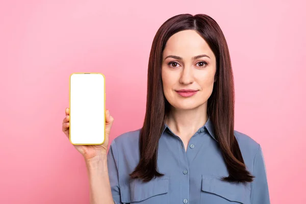 写真の自信深刻なプロモーターブロガーの若い女の子は ピンクの色の背景に隔離された電話空のスペースのスマートフォンの画面のウェブサイトのレンタカー — ストック写真