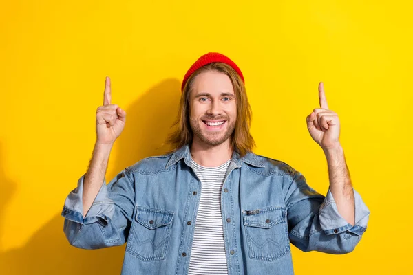 照片上快乐而积极的男人穿着斜纹棉布夹克 手指指向空旷的空间 孤立的黄色背景 — 图库照片