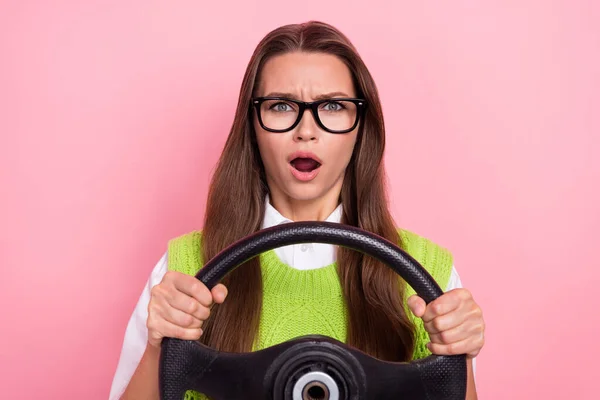 穿着绿色羊毛衫驾驶方向盘汽车抛锚的愤怒女人在粉色背景下被隔离的不满意的震惊照片 — 图库照片