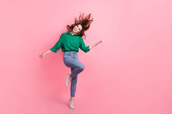 穿着牛仔裤 绿色衬衫 喜欢跳舞的可爱而又乐观的女人的全长照片 在粉色的背景下显得很有趣 — 图库照片