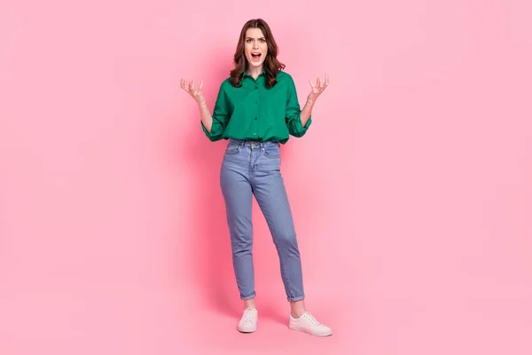 Full length photo of angry mad lady dressed green blouse shouting rising hands arms isolated pink color background.