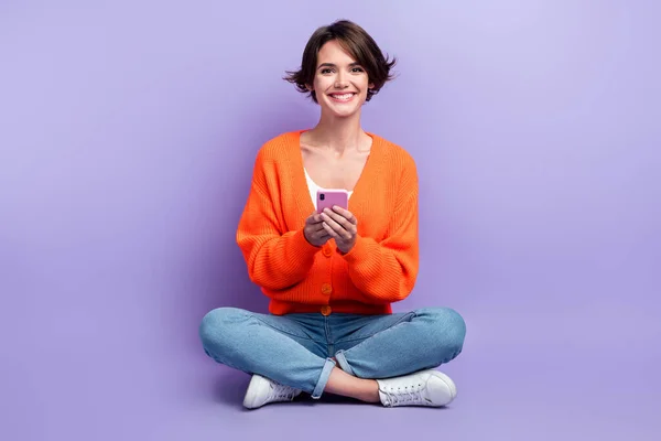 Full body photo advert of millennial funky optimist user gadget review woman promoter hold new apple smartphone isolated on violet color background.