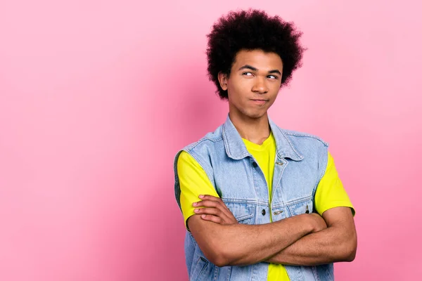 Photo of minded pensive young person folded arms look empty space ponder isolated on pink color background.