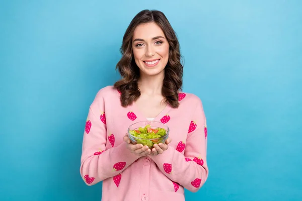 Photo of funny sweet woman wear pink cardigan holding plate enjoying tasty salad isolated blue color background.