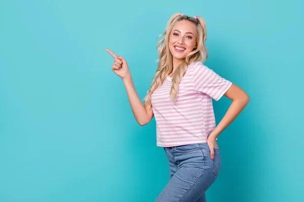Photo of wavy blonde hair gorgeous woman wear stylish pink striped t-shirt recommend direct finger advert mockup isolated on blue color background.