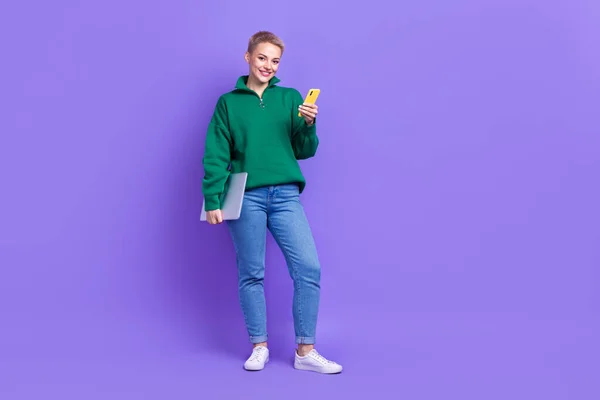 可愛いです女性の完全な長さ写真は緑のセーターを身に着けている現代的なデバイス空のスペース隔離された紫色の背景 — ストック写真