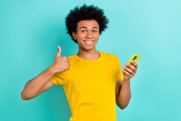 照片上的帅哥满意的非洲发型穿着黄色T恤 看起来像一份漂亮的工作 背景为绿松石色 — 图库照片
