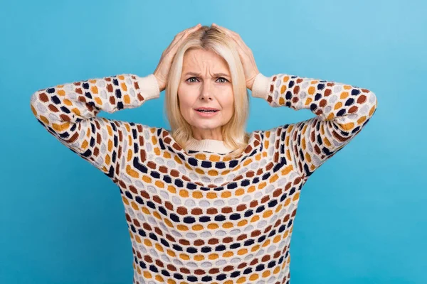 Photo of shocked impressed lady dressed pullover arms head listening bad news isolated blue color background.