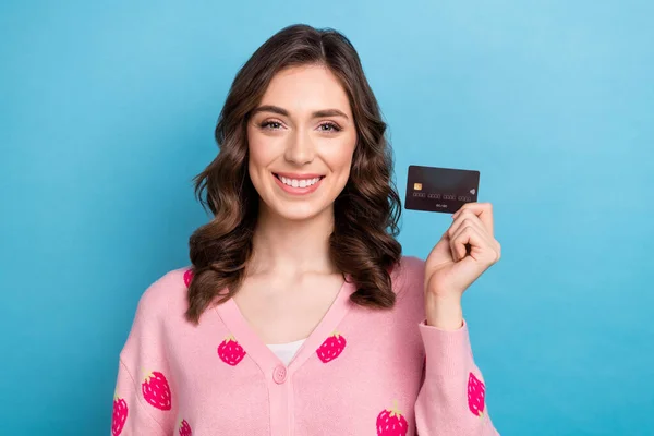 Photo of sweet charming lady dressed pink cardigan rising credit card isolated blue color background.