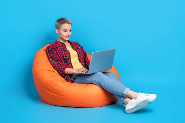 귀여운 양성인 소녀의 체크무늬 셔츠를 채파란 배경에 고립된 노트북 — 스톡 사진