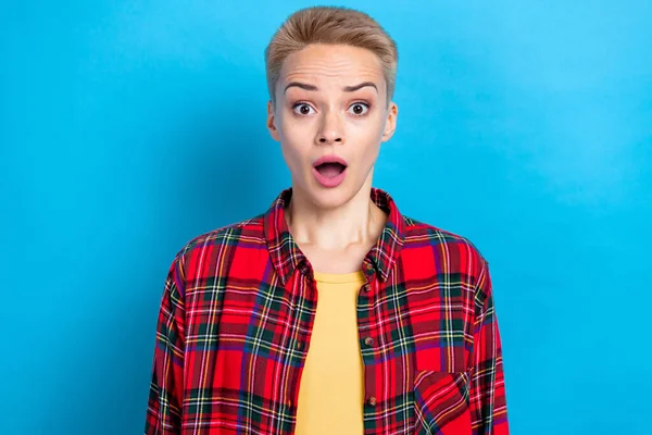 Photo portrait of surprised confused staring blonde short hairdo wear red casual style shirt open mouth bad news isolated on blue color background.