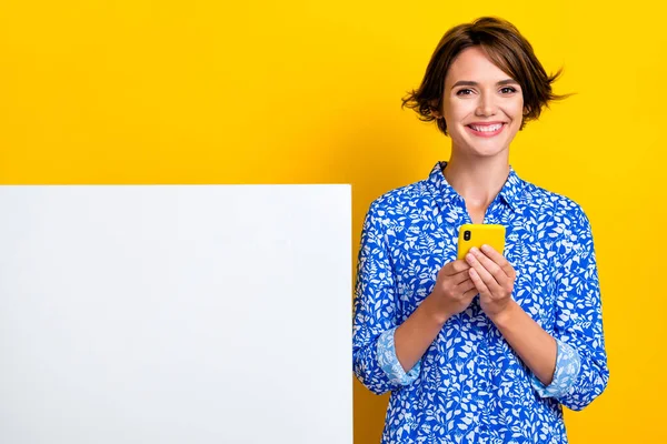 魅力的な若い女性デバイスの写真の肖像白いバナー空のスペース広告は黄色の色の背景に隔離されたスタイリッシュなプリントの外観を身に着けている — ストック写真