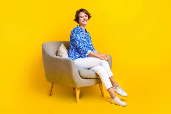 かわいいです女性の服のフル長さの写真プリントシャツ座って居心地の良い椅子孤立黄色の背景 — ストック写真