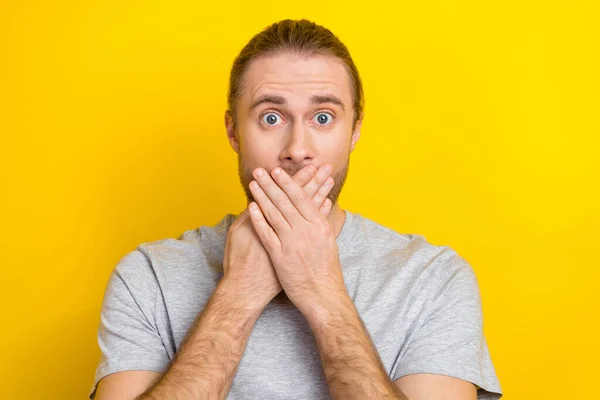 Photo of worried nervous man wear stylish cloths arms cover mouth ears impressed bad news isolated on yellow color background.