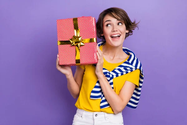 照片上快乐可爱的可爱女士穿着时髦条纹衣服拿着礼品盒空旷的空间隔离在紫色的背景下 — 图库照片