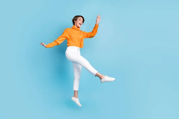 魅力的な若い女性のジャンプダンスのフルボディ写真は青の色の背景に隔離された軽量でエレガントな服を着たスタイリッシュなオレンジの外観をお楽しみください — ストック写真