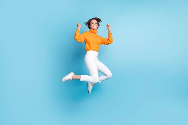 기사보기 스러운 숙녀가 점프하는 전체가 배경에 주황색 복장을 행운을 축하하는 — 스톡 사진