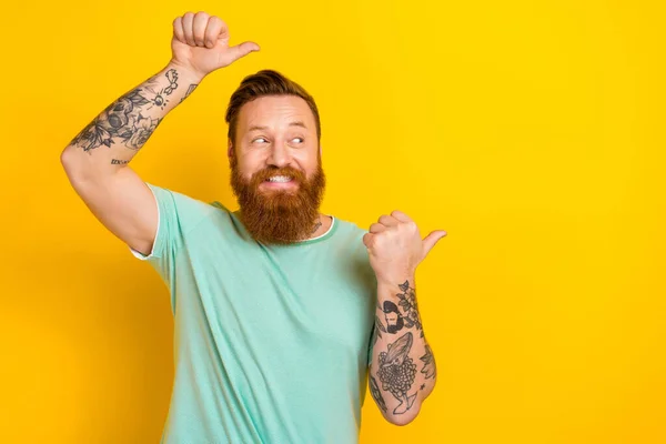 Photo of cheerful satisfied person indicate fingers empty space proposition isolated on yellow color background.