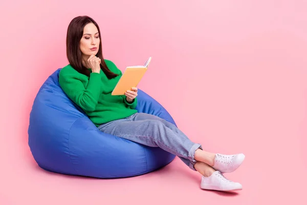 フルボディ写真の心の深刻な女性座って快適なバッグ手タッチ顎読み本孤立したピンク色の背景 — ストック写真