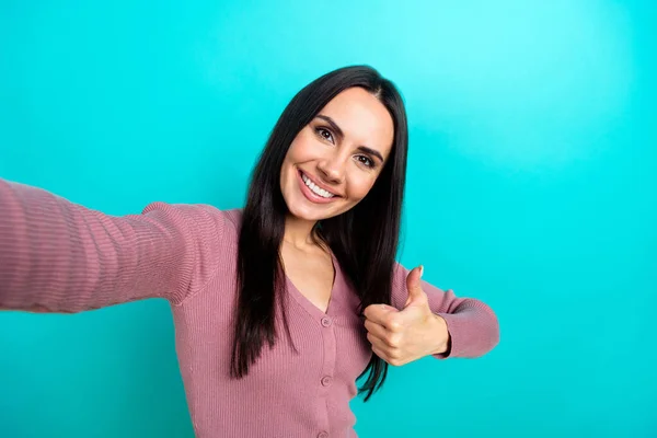 Portrait of positive pretty woman pastel clothes making selfie showing thumb up nice job isolated on shine turquoise color background.