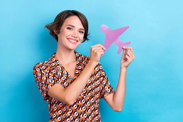 Photo of funky sweet woman wear print blouse smiling rising paper plane isolated blue color background.