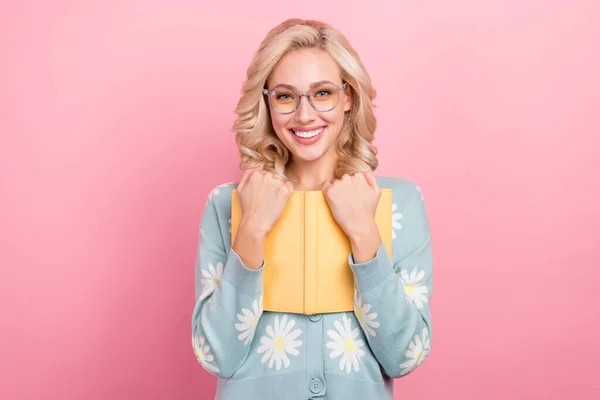 若い女の子のメガネの写真は ピンクの色の背景に隔離されたオタクストア学術服デイジーフラワープリントシャツからお気に入りの本を抱擁 — ストック写真