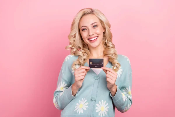 Portrait of nice lovely lady beaming smile hands hold showing debit card isolated on pink color background.