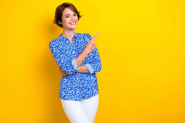 照片上 滑稽的积极女子穿着蓝色衬衫 手指指向空旷的地方 孤立的黄色背景 — 图库照片
