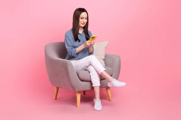 自信のあるインフルエンサービジネスブロガー成熟した年齢テキストメッセージ女性同僚座っているアームチェアピンク色の背景に隔離された — ストック写真