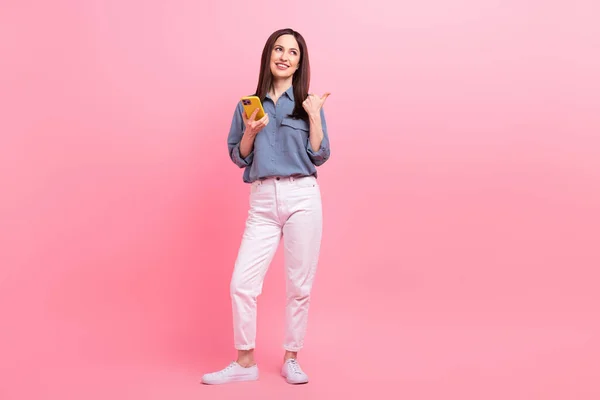 可愛い起業家の若い年齢の完全な長さの写真は ピンクの色の背景に隔離されたスマートフォンの直接親指のモックアップ見てオンライン商取引を保持 — ストック写真