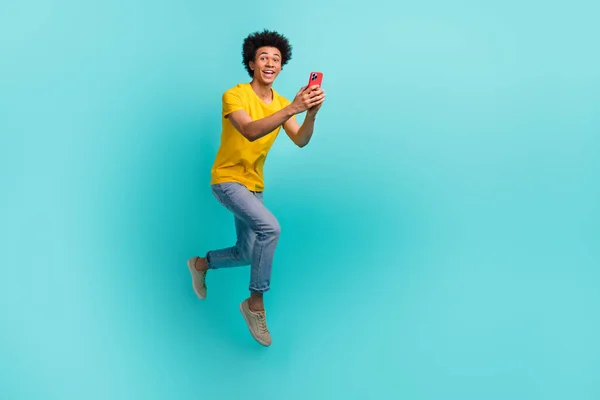 全长兴奋的男子跳跃冲刺的照片用智能手机空出的空间隔离在单调的色彩背景下 — 图库照片