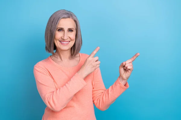 市场营销员 退休女士穿着桃色衬衫的照片 手指空空如也 新的商业保险在蓝色背景下被隔离 — 图库照片