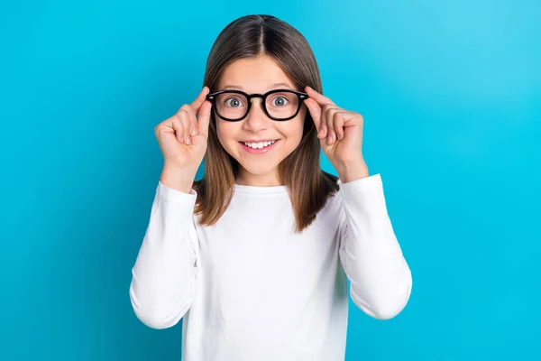 長い髪型の印象的な女の子の写真は 青の色の背景に隔離された見つめて白い長い袖の指のタッチメガネを着用 — ストック写真