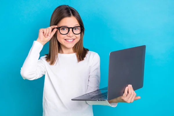 穿着白色长袖触摸眼镜 心满意足的长发女孩的照片 拿着用蓝色背景隔开的笔记本电脑 — 图库照片