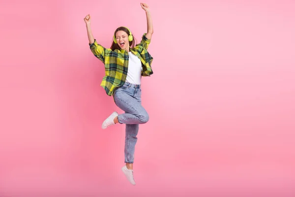 フル長さサイズのクレイジー素晴らしい若い女性リッスン新しいソニーのヘッドフォン手アップジャンプ屈託のない大きな音楽絶縁上ピンク色の背景 — ストック写真