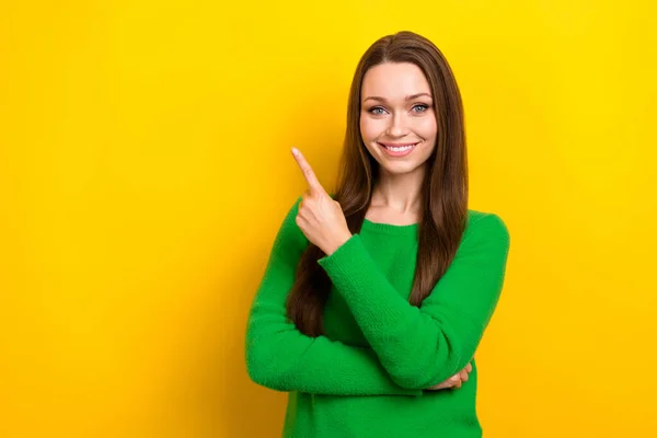 Portrait of positive lovely lady beaming smile direct finger empty space isolated on yellow color background.