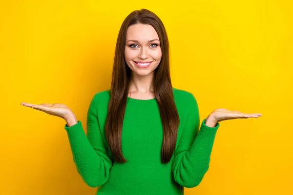 照片上 快乐而积极的女士身穿绿色套头衫 与臂膀凸起的空间相比较 孤立的黄色背景 — 图库照片