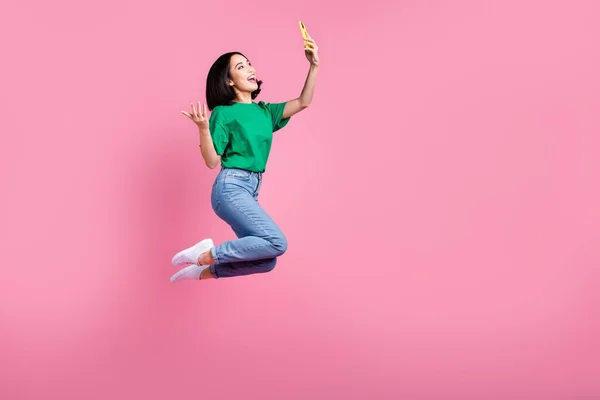 フル長いですボディ写真の若いですアクティブ韓国の女の子ブロガーホールドスマートフォン録画ビデオの話とともに加入者と隔離されたピンク色の背景 — ストック写真