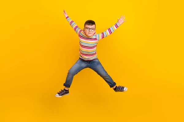 フル長いです写真の活動的な子供男の子ジャンプアップ手孤立上の鮮やかな色の背景 — ストック写真