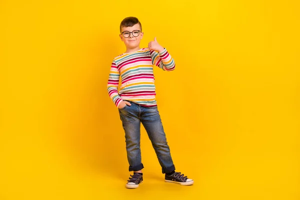 Full length photo of positive man wear quality jeans clothes thumb up recommend buy empty space isolated on yellow color background.