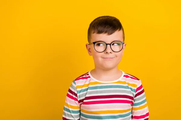 stock image Photo of positive boy wear striped stylish clothes interested look empty space school supplies isolated on yellow color background.