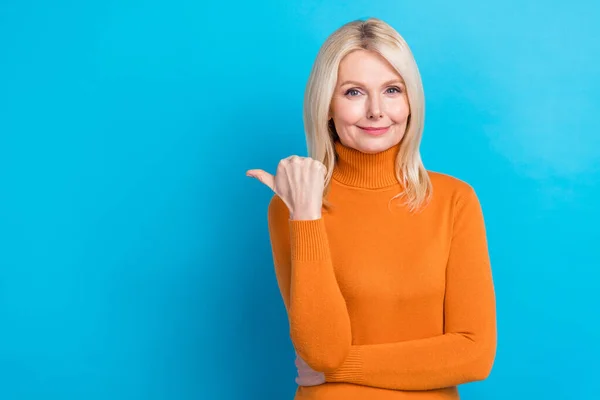 ブロンド髪の写真定年退職したビジネス女性は 流行のオレンジ色のセーターポイント指空のスペース広告を着用シアン色の背景に孤立 — ストック写真