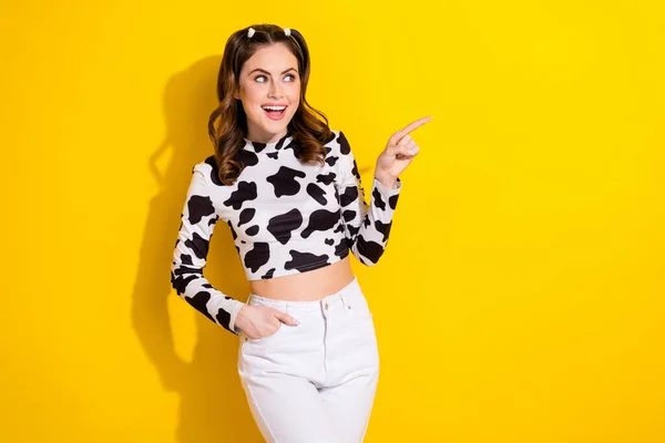 写真の感動的な女の子は空のスペースを指している牛の皮のシャツを着て黄色の背景を隔離 — ストック写真