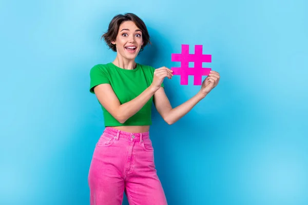 Photo of funny surprised girl brown bob hairstyle hold paper hashtag social media advert repost popular video isolated on aquamarine color background.