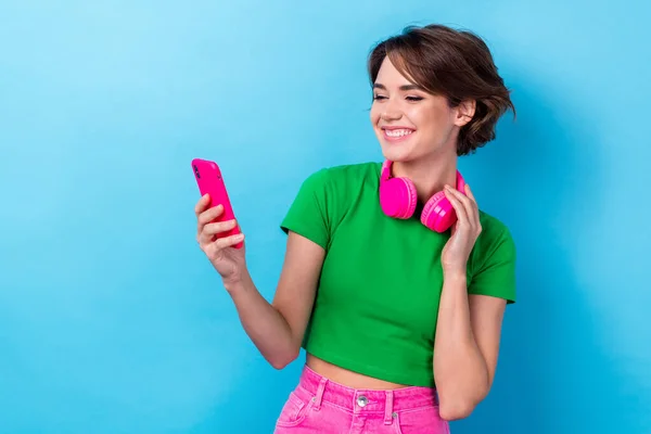 Photo of funky shiny woman wear green t-shirt listening songs apple samsung device empty space isolated blue color background.